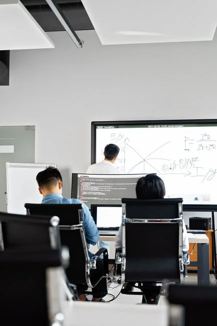 Dual monitors on a desk, showcasing web design in a modern office setting.